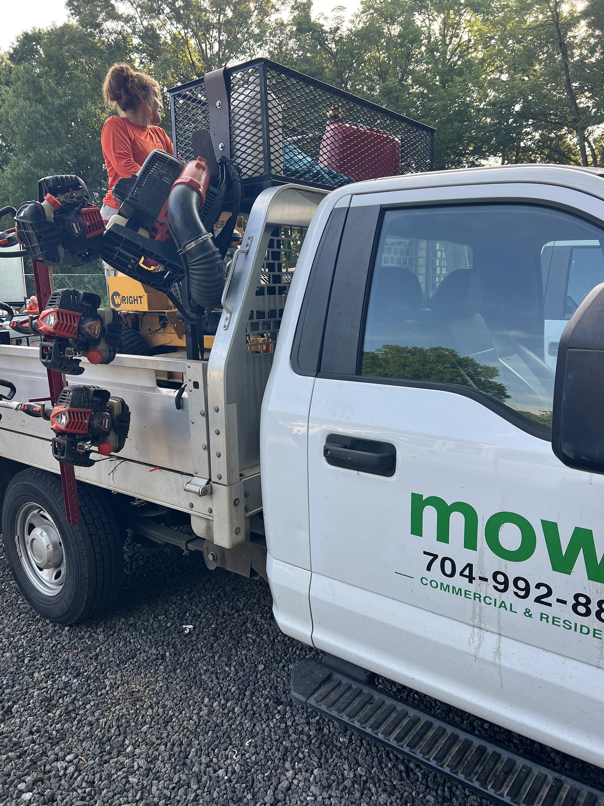 A loaded Mow, Inc. flatbed truck with trimmers, blowers and a stand-on mower ready for the day's route