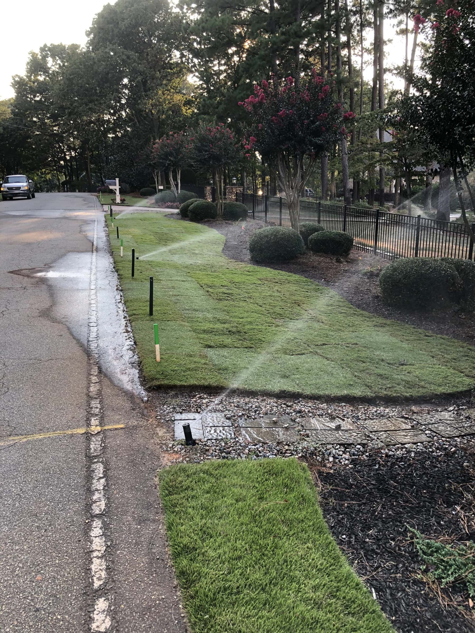 Irrigation heads running across newly laid sod along a street frontage