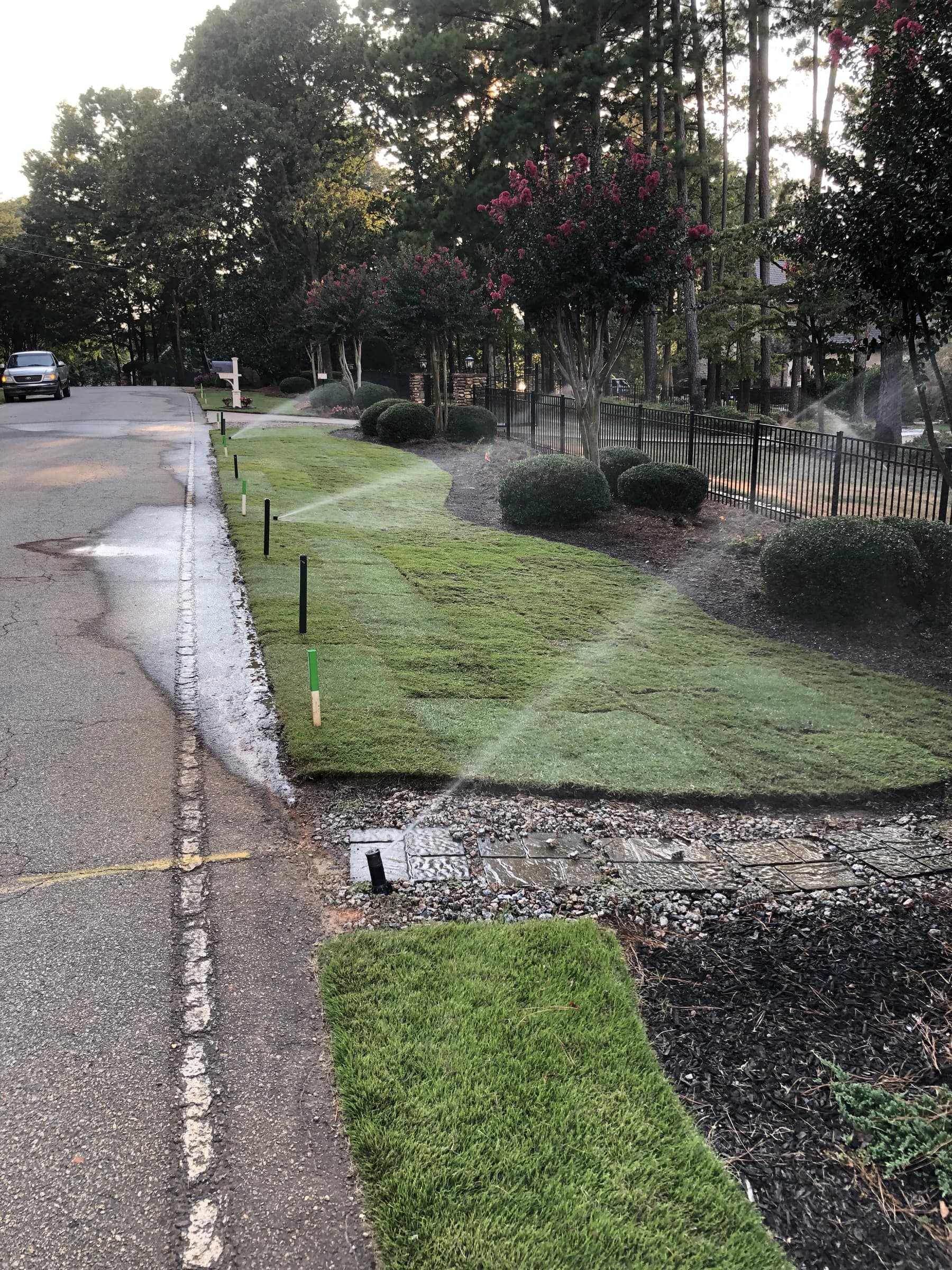 Irrigation heads running across newly laid sod along a street frontage