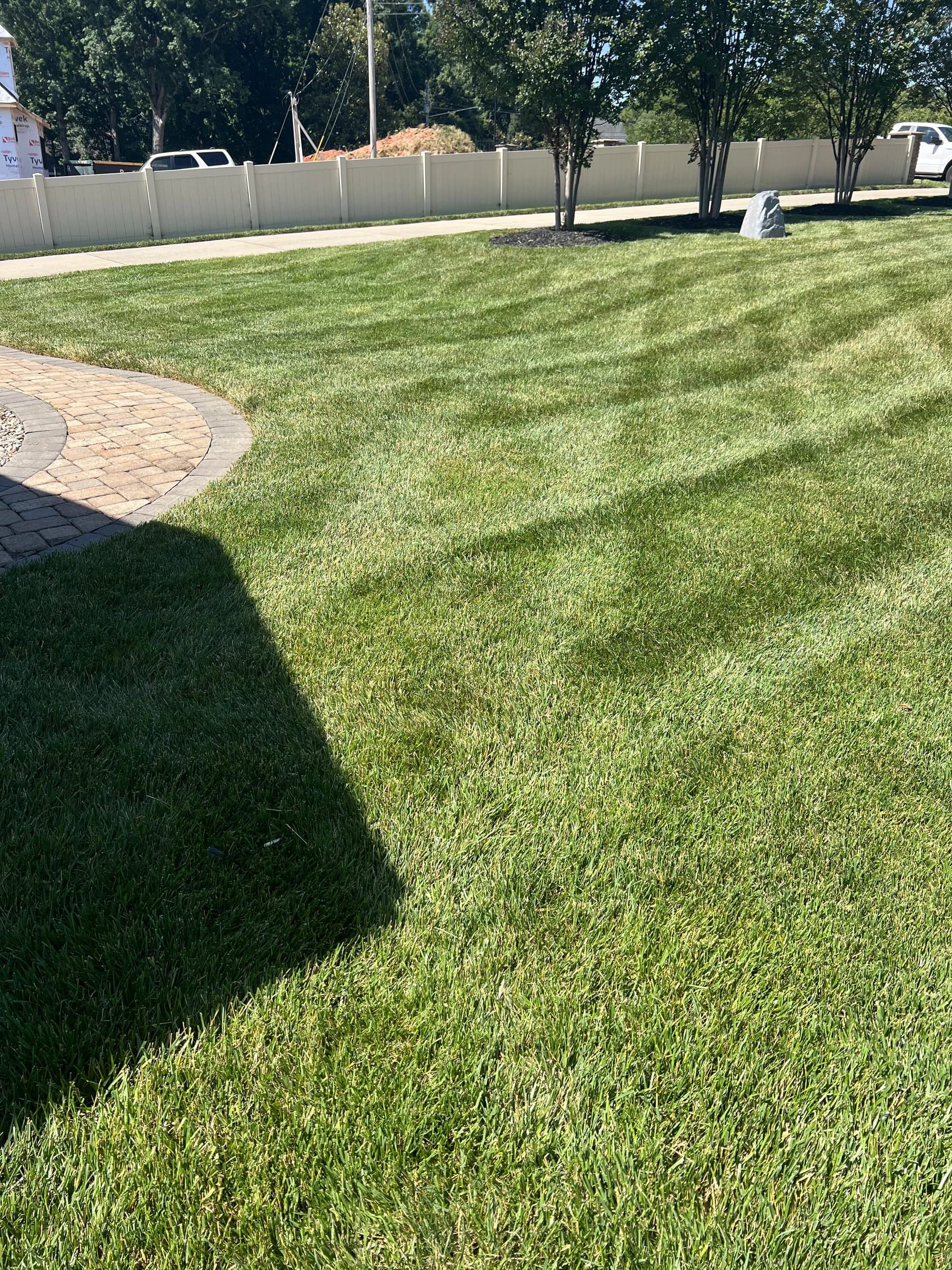 Mown turf curving around a circular paver patio