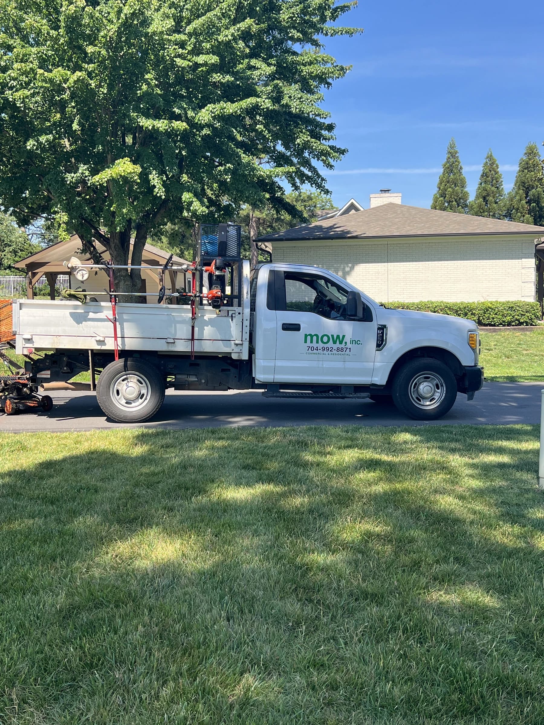 A loaded Mow, Inc. equipment truck parked at a job site